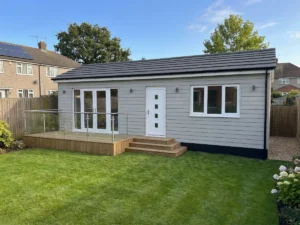 A pitched roof Winchester annexe with white windows and doors and a compact timber decking area.