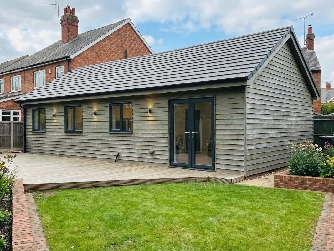The greenwich 2 bedroom annexxe with green oak cladding and a tiled roof, set in a suburban garden.